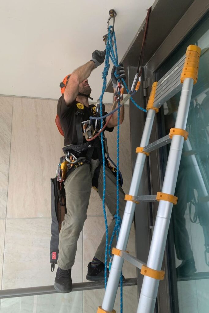 Worker hooked into his harness getting ready for a caulking job.