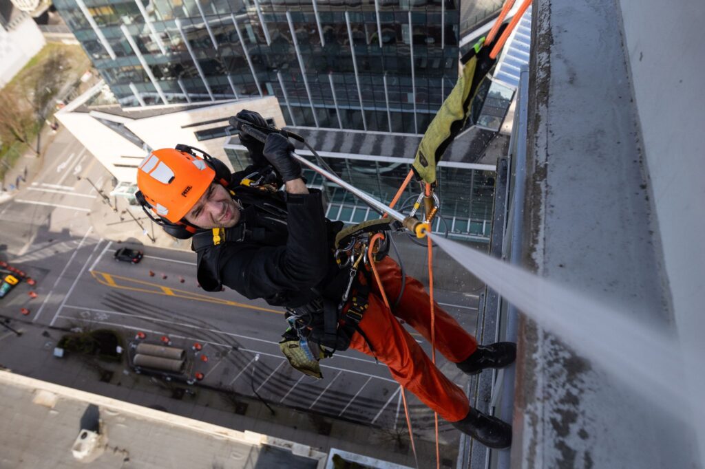pressure washing person doing building maintenance services in vancouver